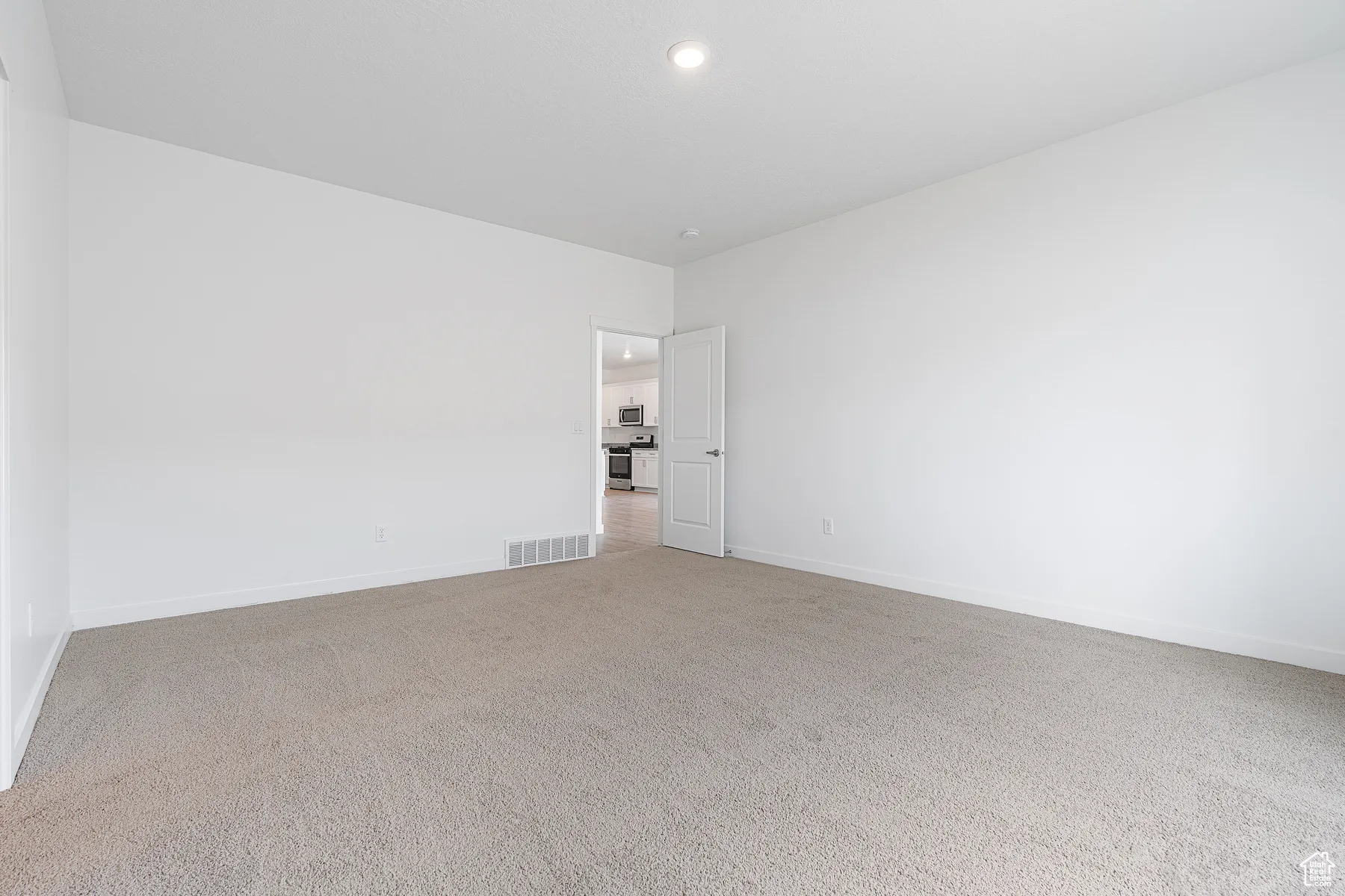 Empty room with carpet flooring and recessed lighting