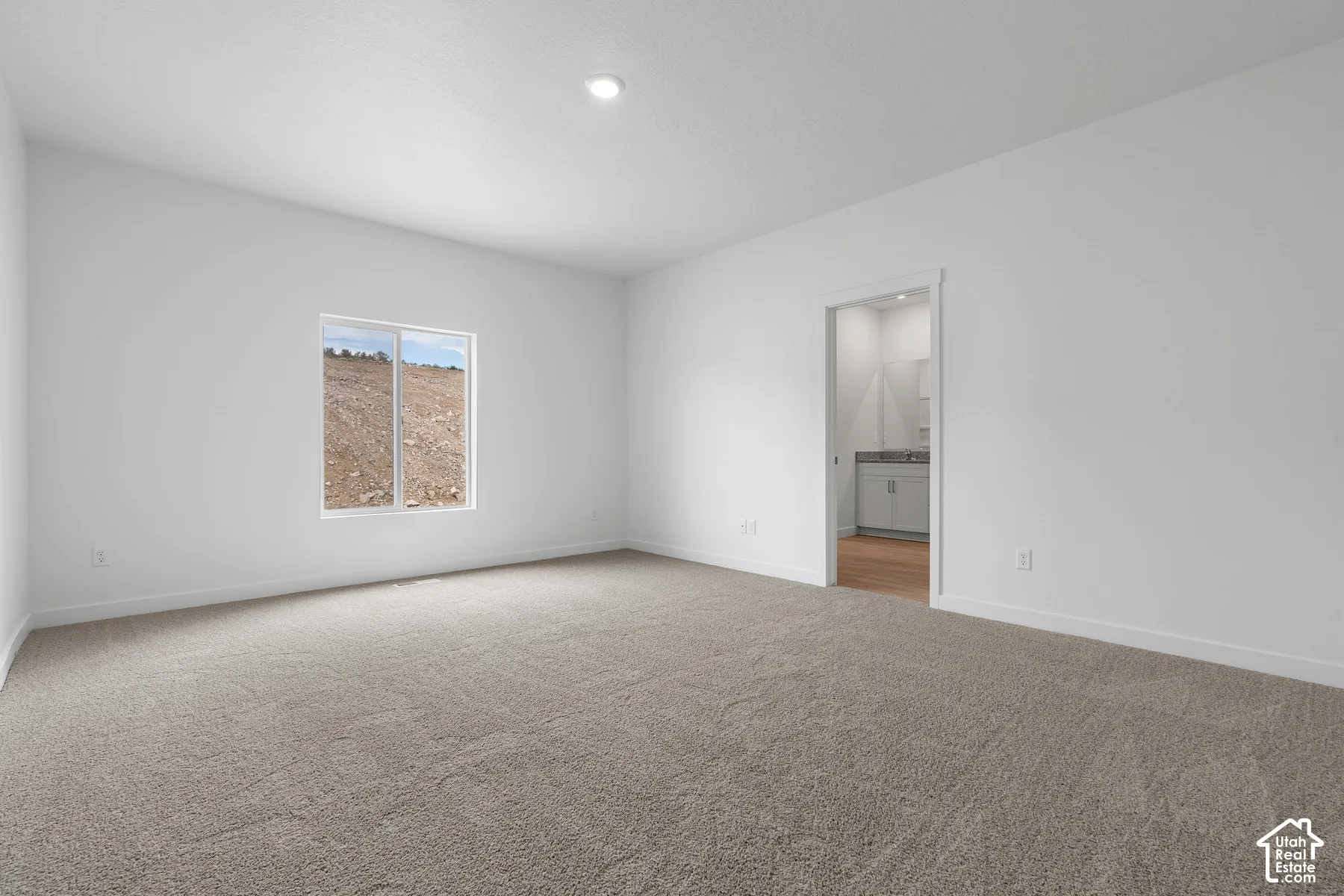 Unfurnished bedroom with light carpet, recessed lighting, and ensuite bath