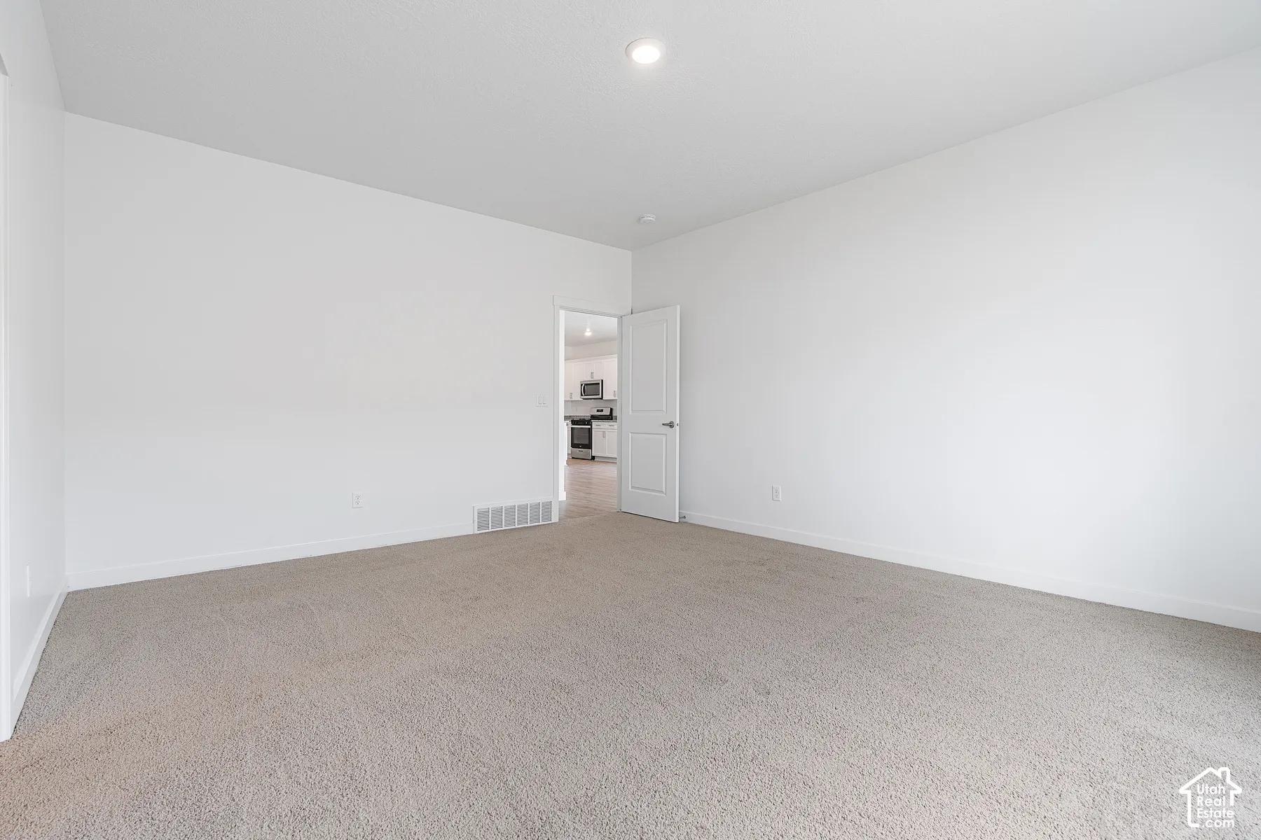 Empty room with carpet flooring and recessed lighting