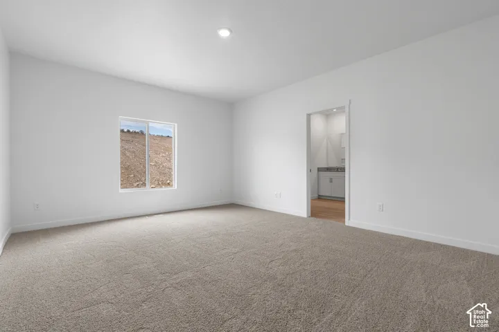 Unfurnished bedroom with light carpet, recessed lighting, and ensuite bath
