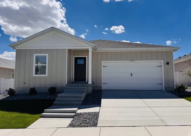 Light-colored exterior siding with white trim accents and a dark entry door