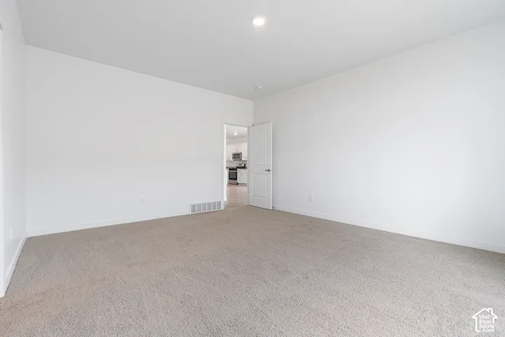 Empty room with carpet flooring and recessed lighting