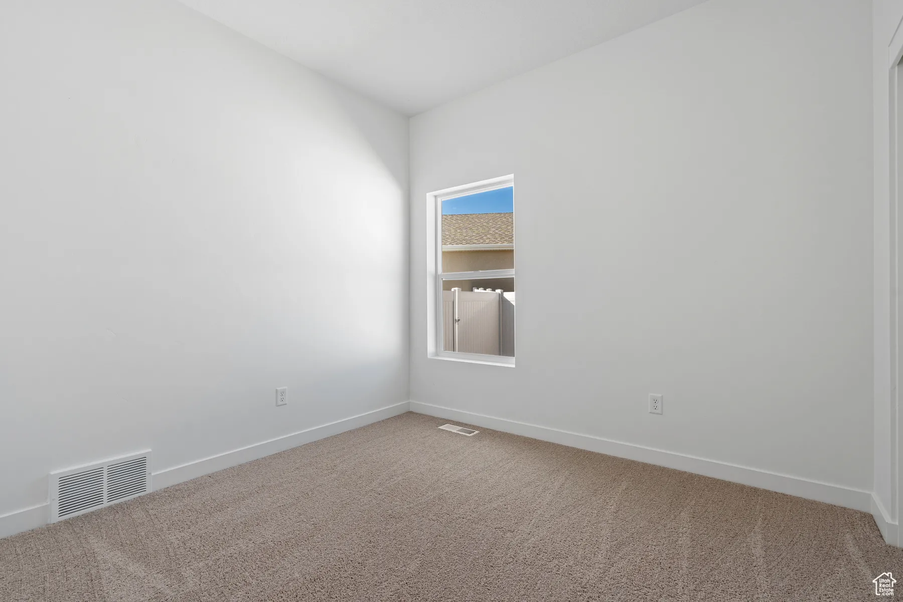 Spare room featuring carpet flooring and baseboards
