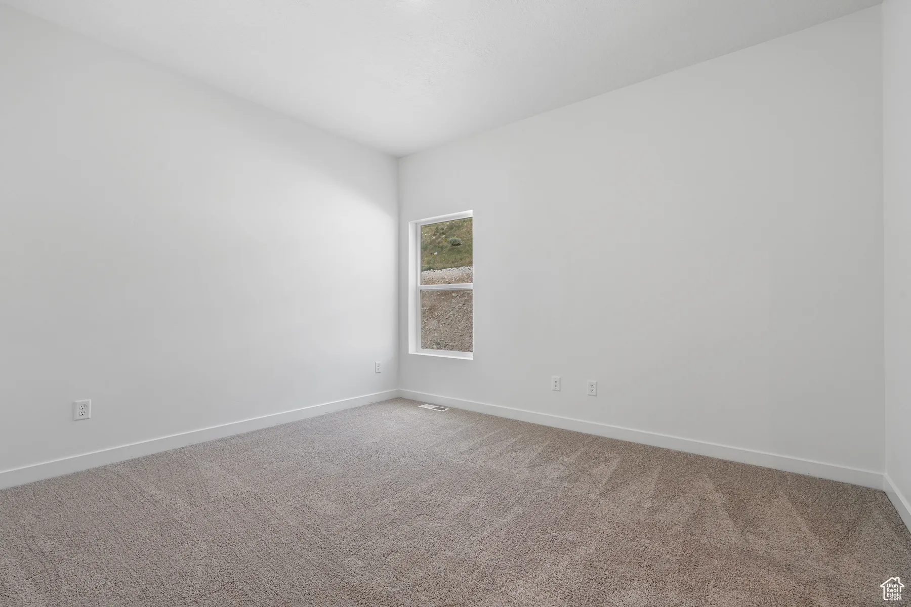 Carpeted empty room with baseboards