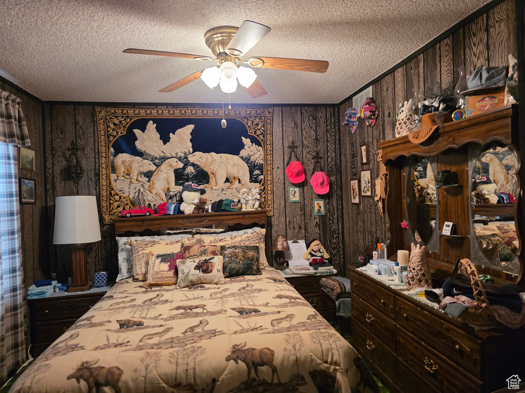 Bedroom featuring a textured ceiling, wood walls, and ceiling fan