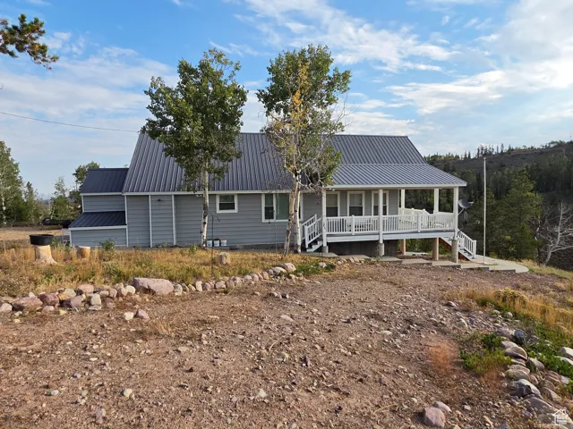 View of front of house featuring a metal roof and a porch