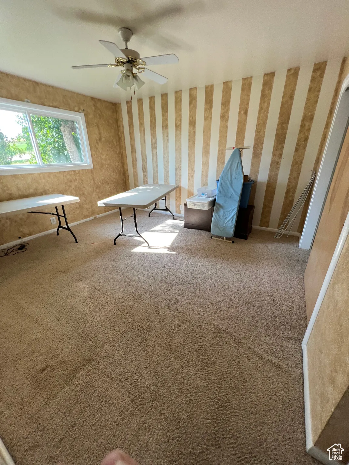 Unfurnished room with carpet, wallpapered walls, and ceiling fan