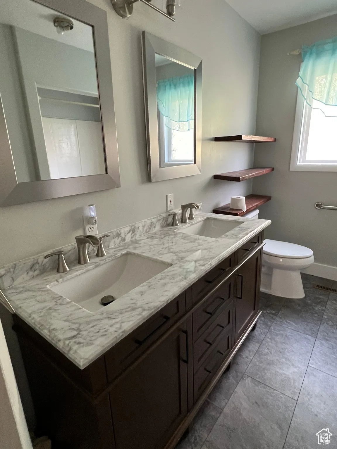 Full bath with double vanity and dark tile patterned floors