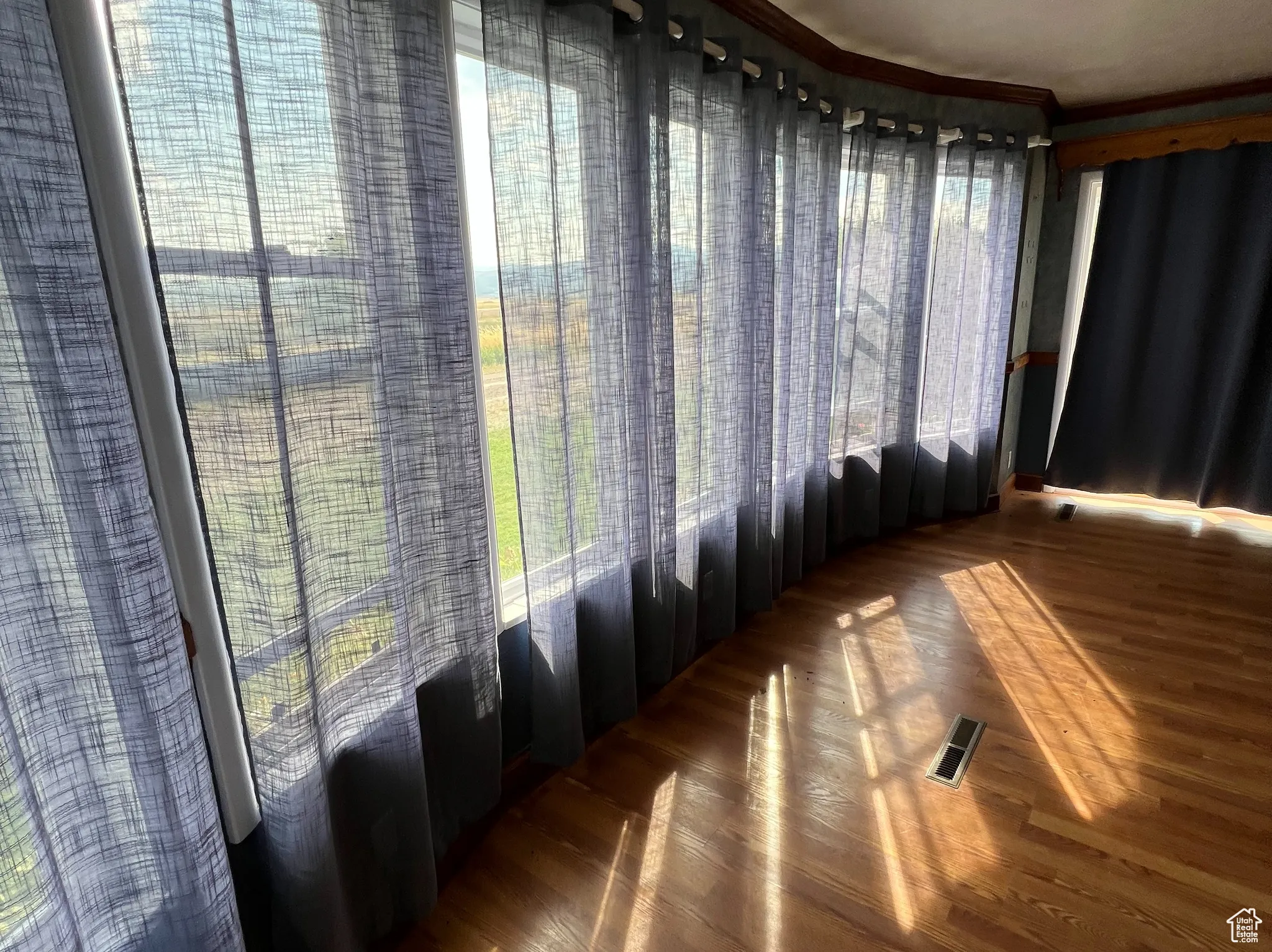 Unfurnished room featuring plenty of natural light and wood finished floors