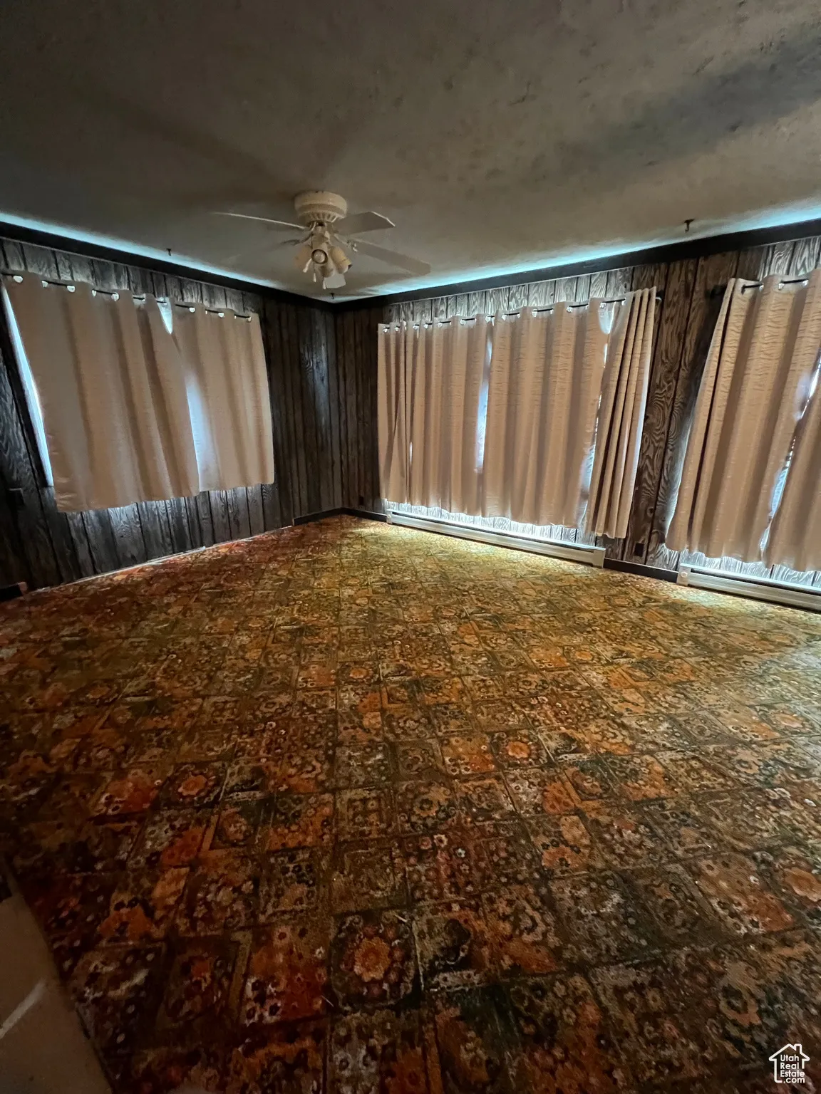 View of yard with baseboard heating and a ceiling fan