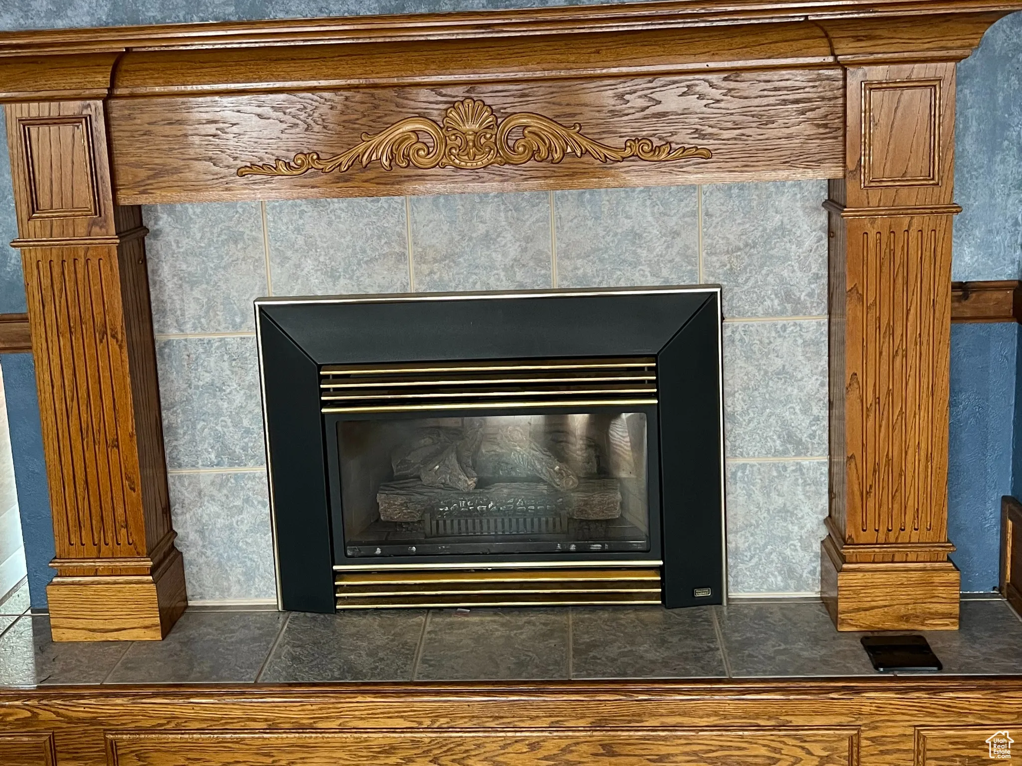 Detailed view of a tiled fireplace and wood finished floors