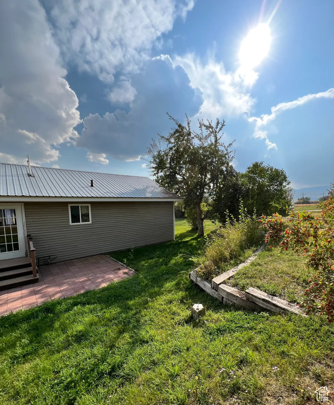 View of grassy yard with a patio area