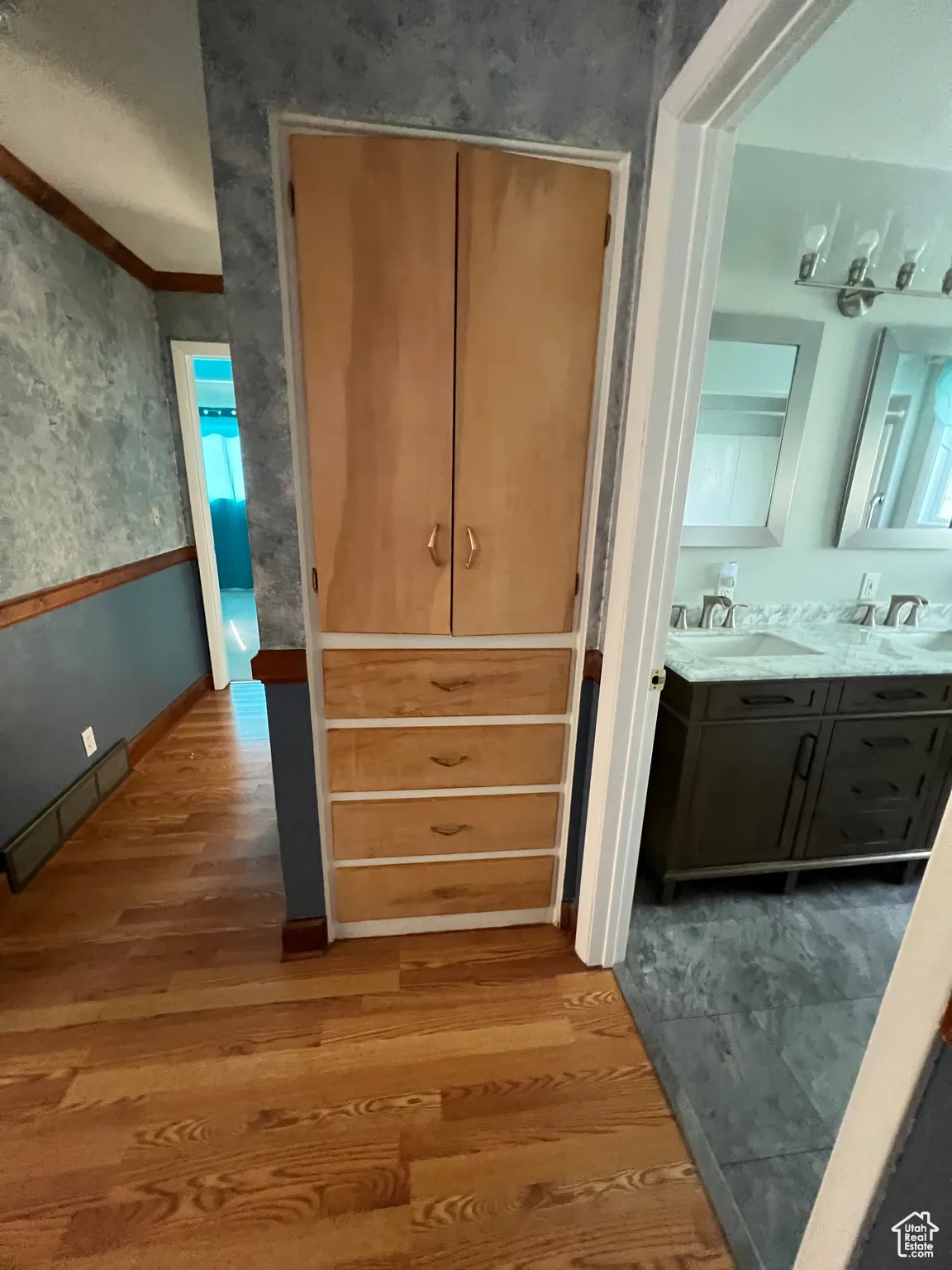 Closet with baseboard heating and a sink
