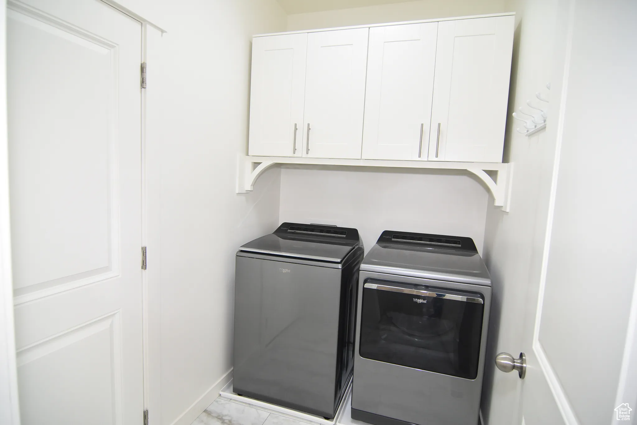Laundry area with washer and dryer and cabinet space and access to 2-car garage,