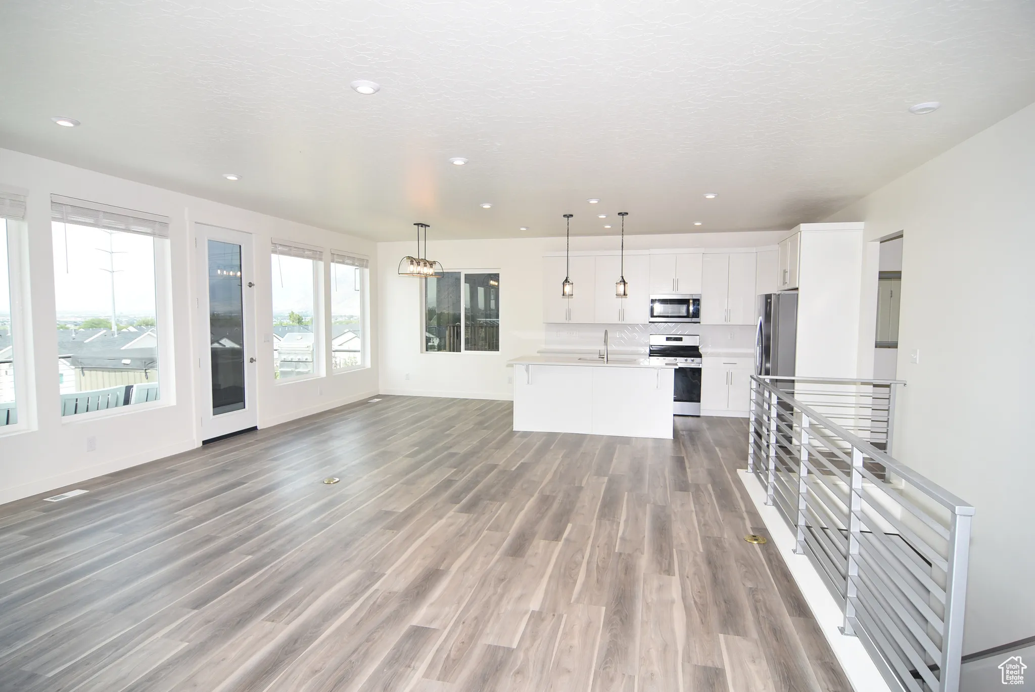 Great room, full kitchen and dining area.  Metal railings and decorative lighting
