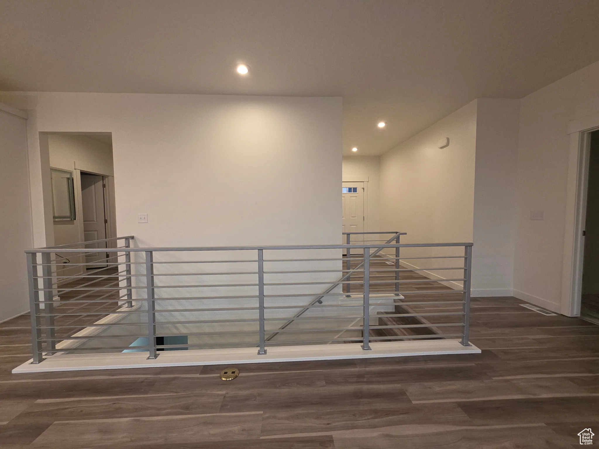 Staircase with wood finished floors and recessed lighting