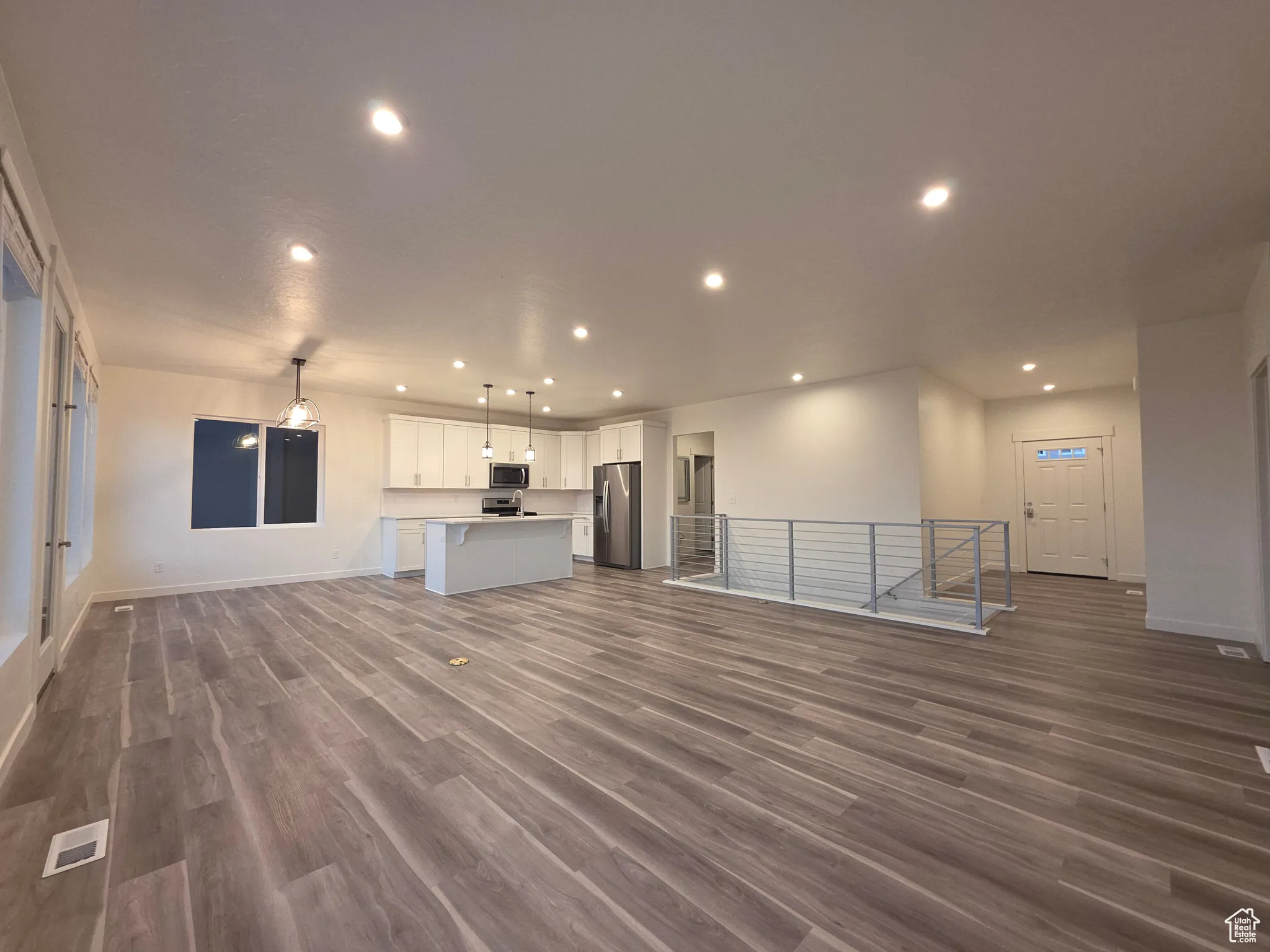 Unfurnished living room with dark wood-type flooring and recessed lighting