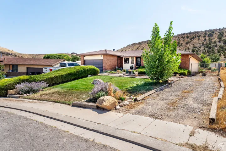 Single story home with brick siding, a mountain view, and a front yard
