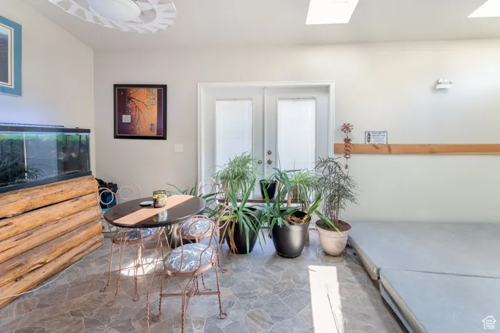 Dining room with stone flooring, french doors, and a skylight