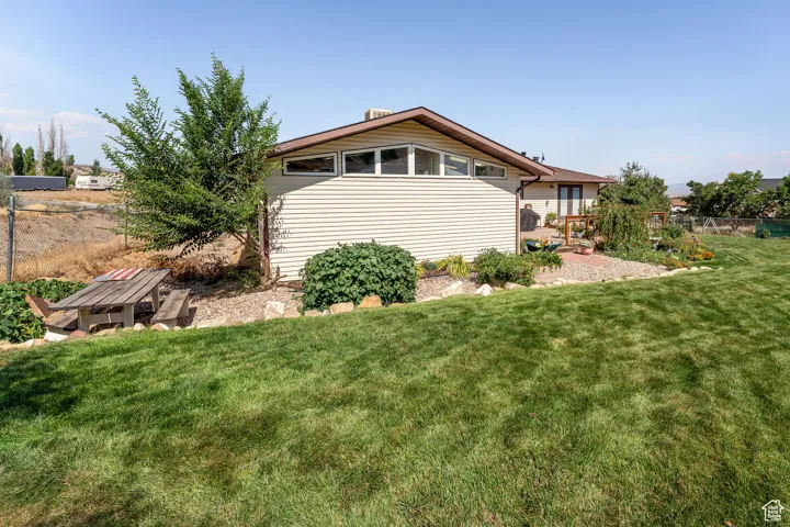 View of property exterior with a patio area and a wooden deck