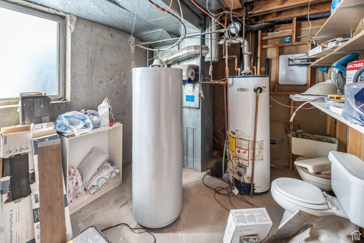 Utility room featuring water heater and gas water heater