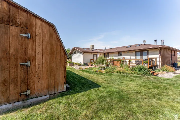 Back of property with a yard and an outdoor structure