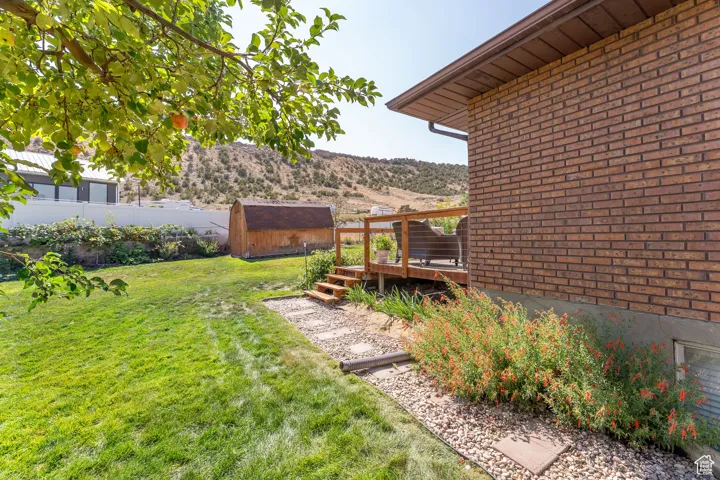 View of yard with a shed and a wooden deck