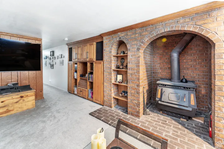Living area featuring a wood stove and light carpet