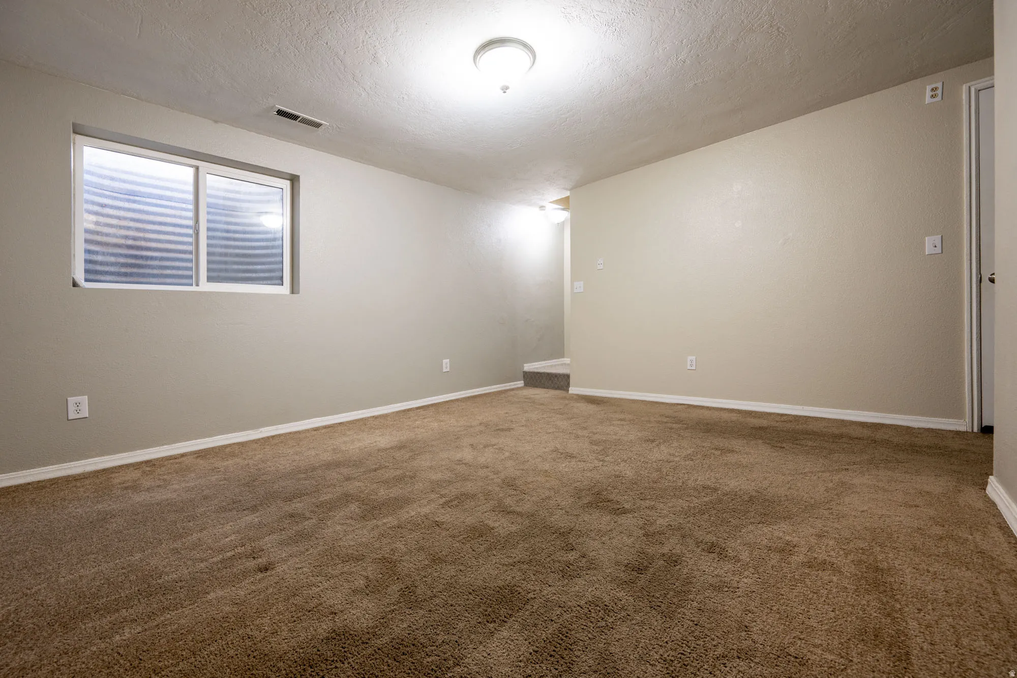 Family room featuring dark carpet and a textured ceiling