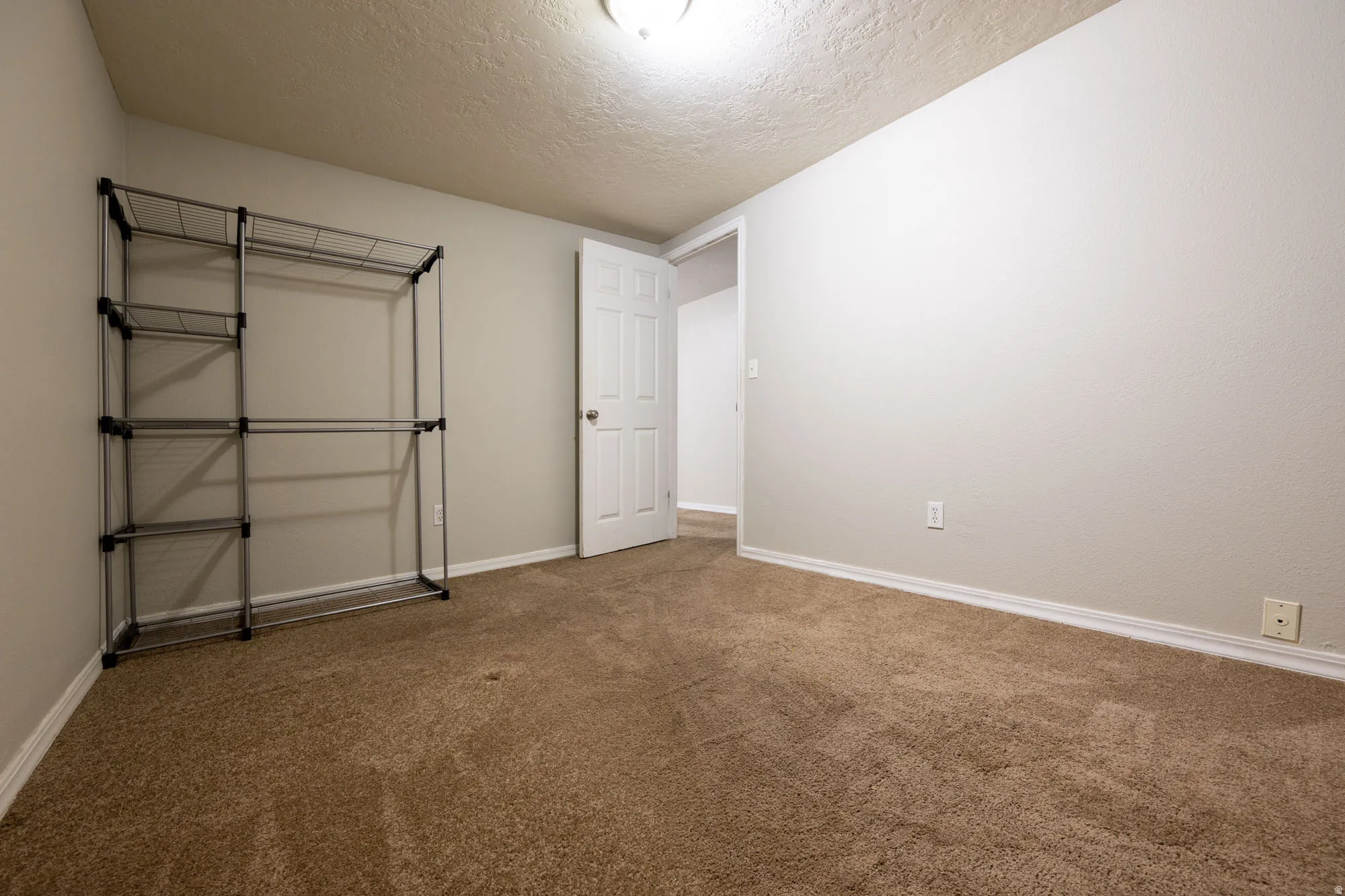 Unfurnished bedroom with carpet flooring and a textured ceiling
