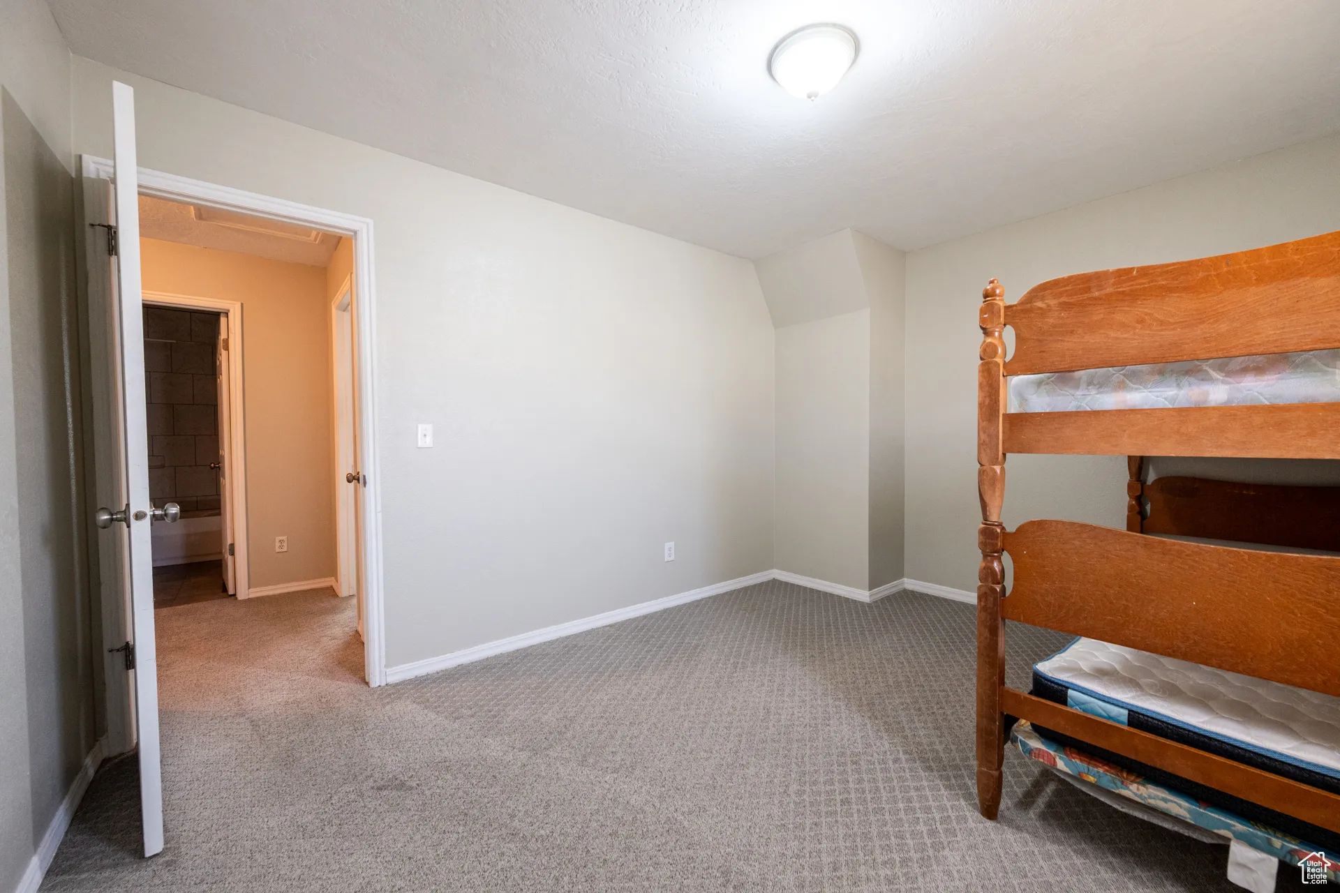 Bedroom featuring light carpet and baseboards
