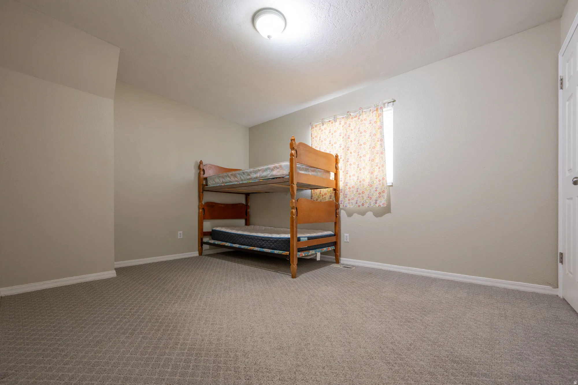 Bedroom with light carpet and baseboards