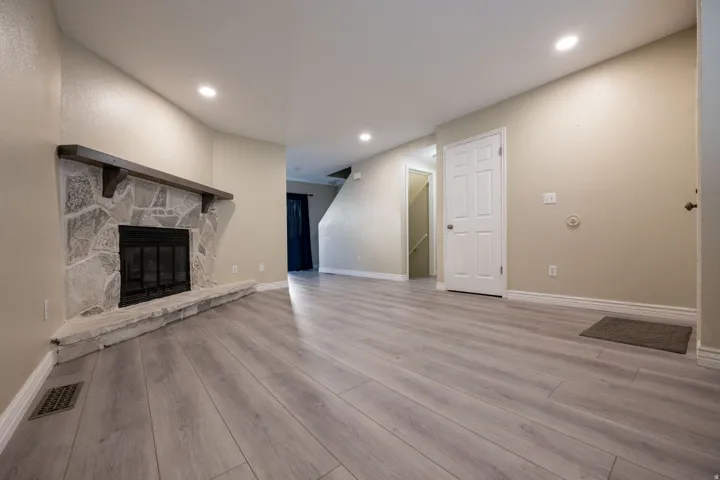 Unfurnished living room with light wood-type flooring, a fireplace, and recessed lighting