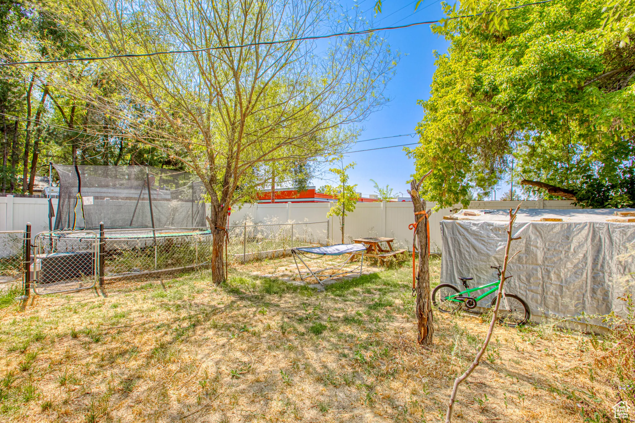 Fenced backyard featuring a trampoline