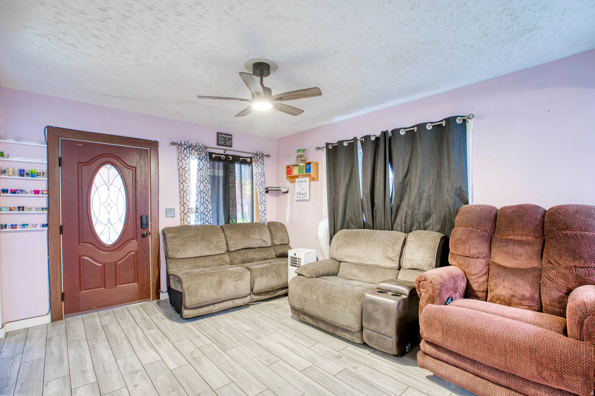 Living area featuring ceiling fan, a textured ceiling, and wood finished floors