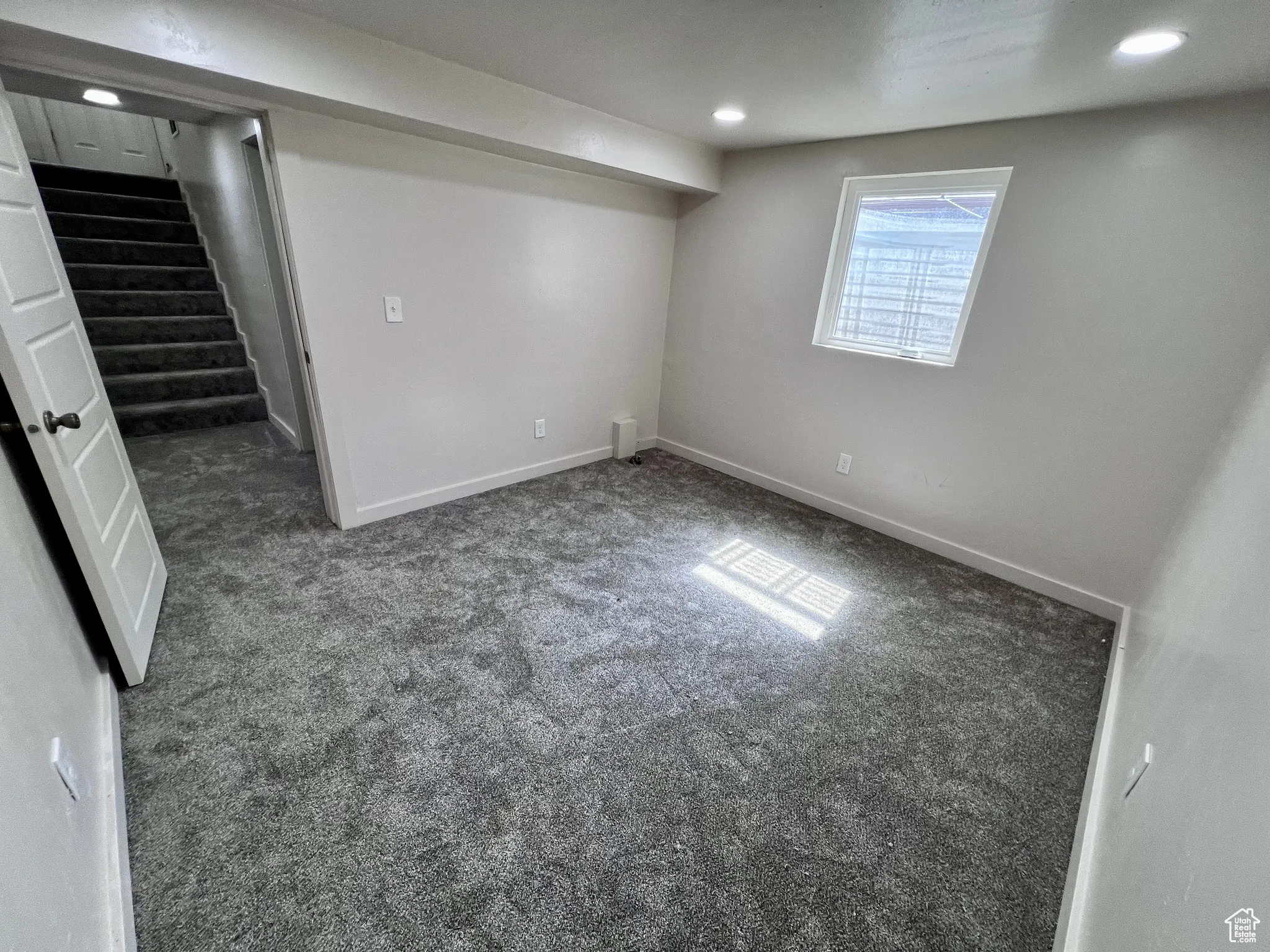 Basement featuring carpet, stairs, and recessed lighting