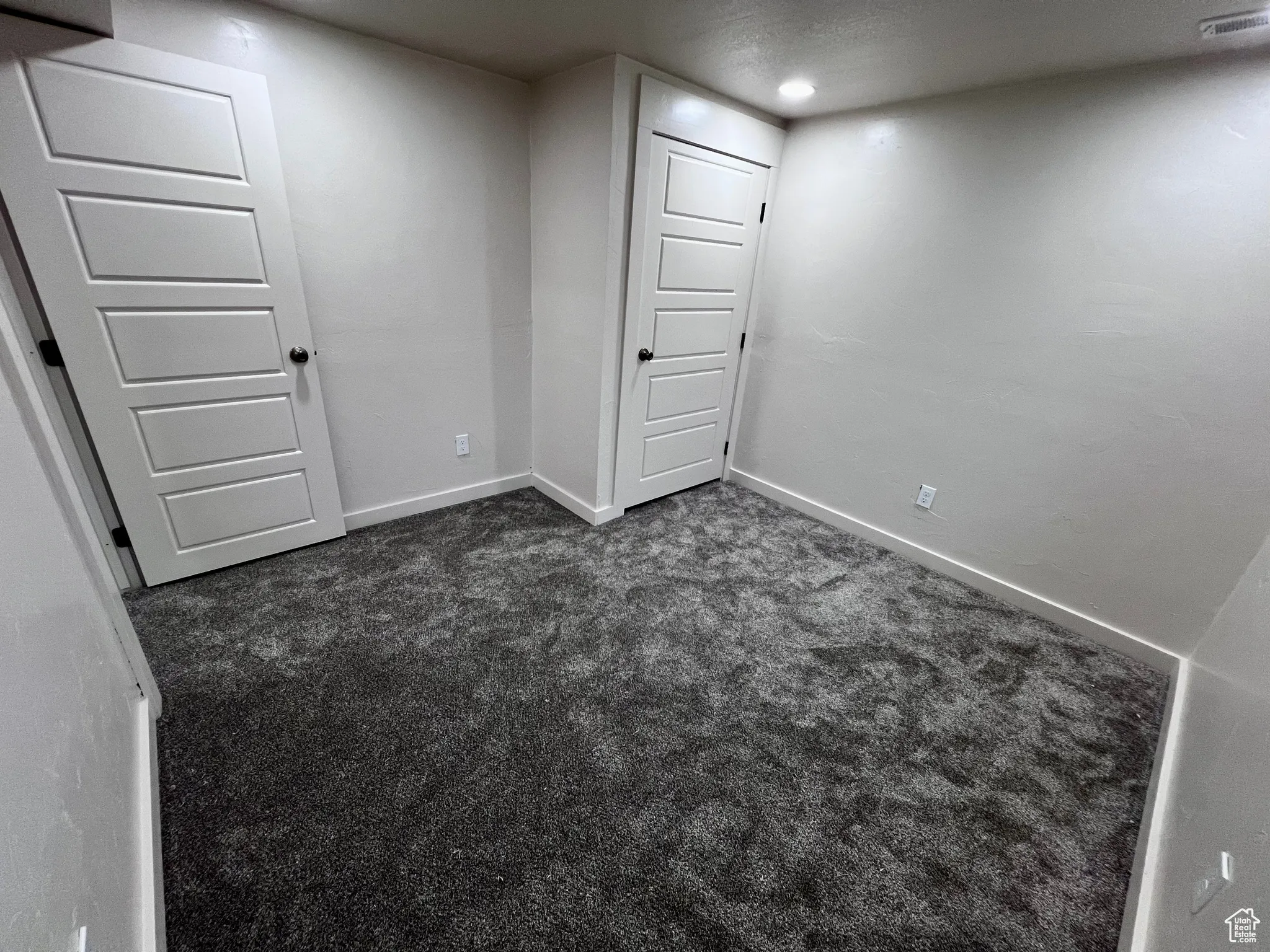 Basement with dark carpet and baseboards