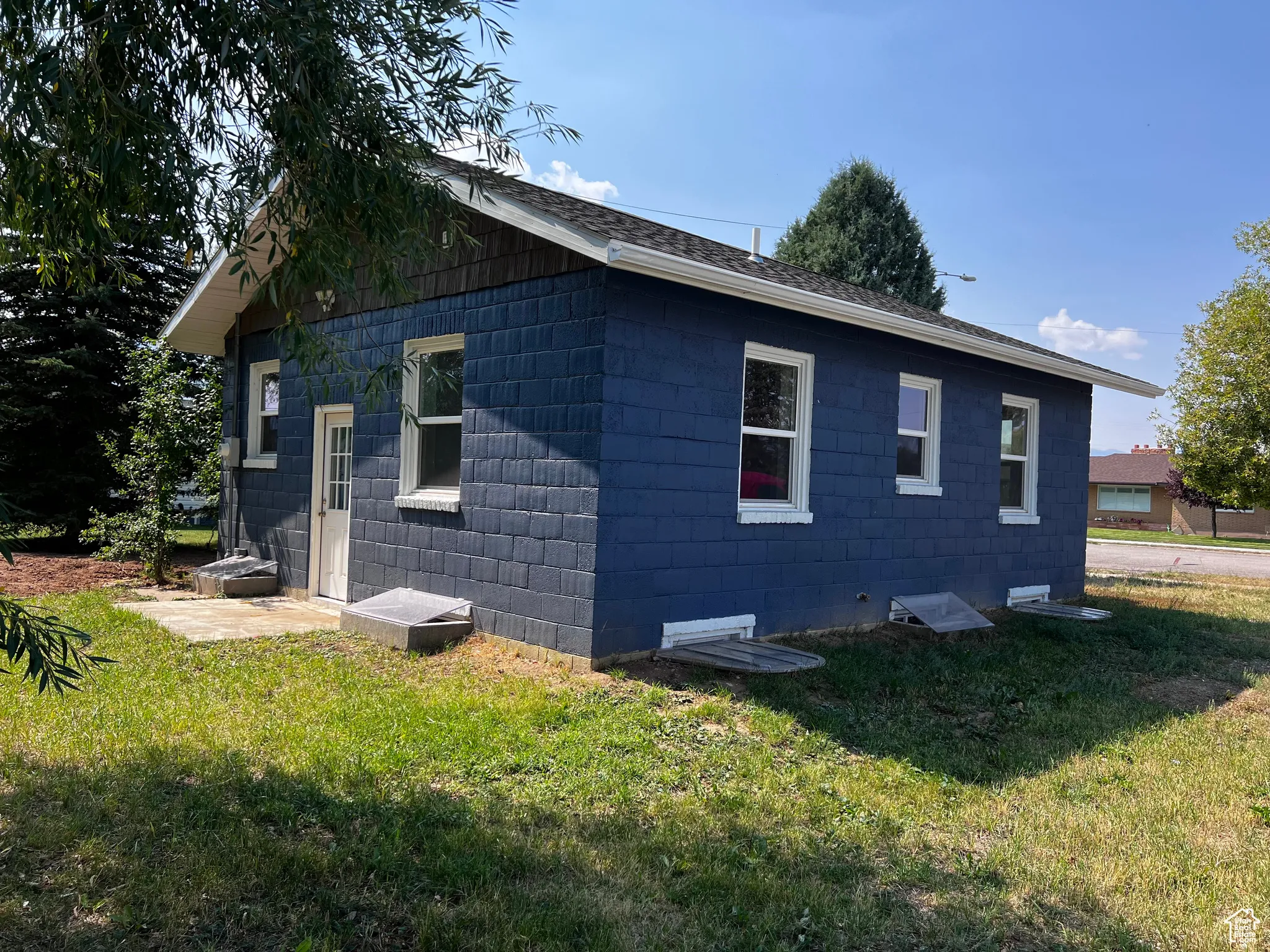 View of property exterior with a yard and concrete block siding