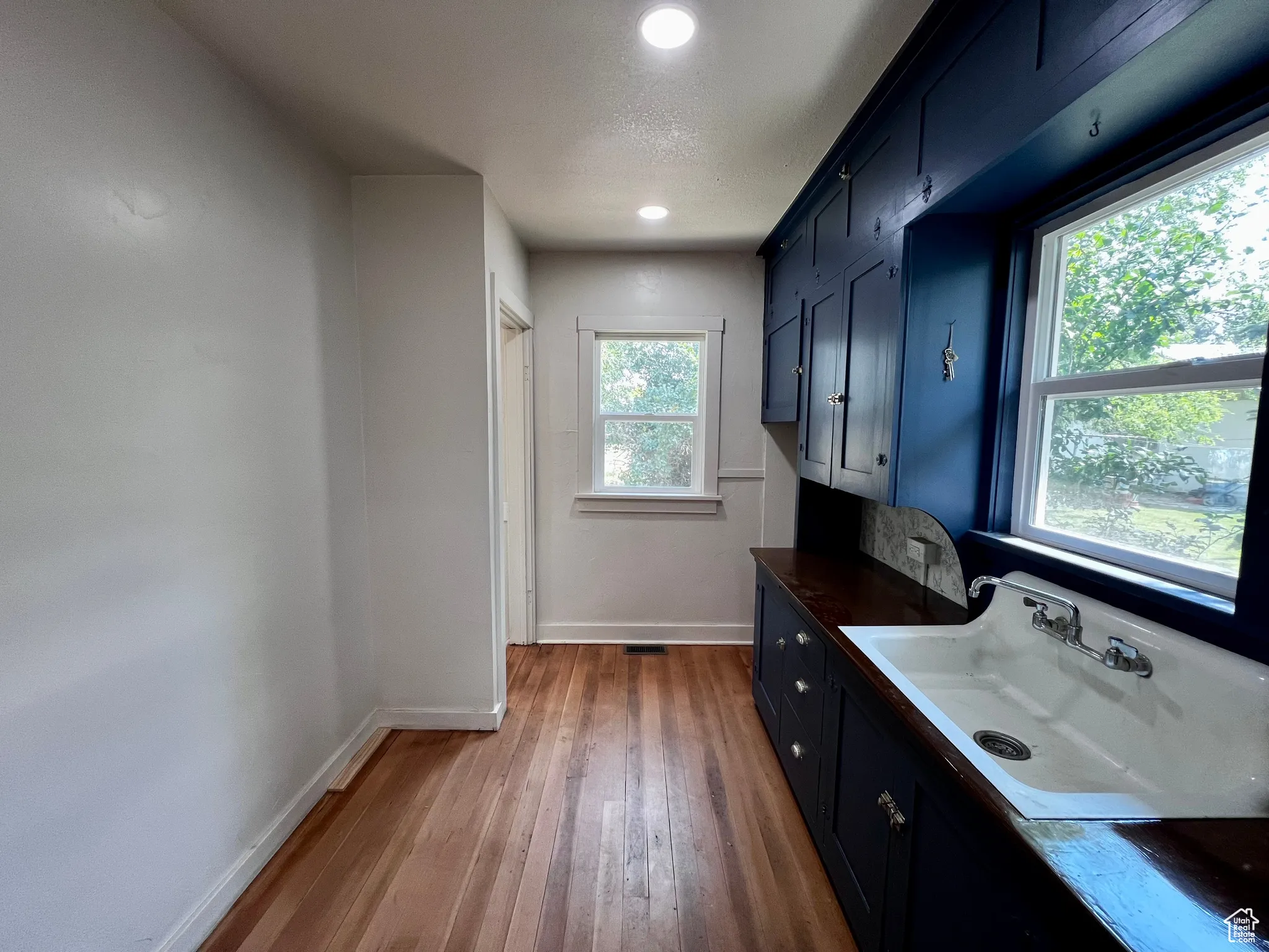 Laundry room featuring dark wood-type flooring and recessed lighting