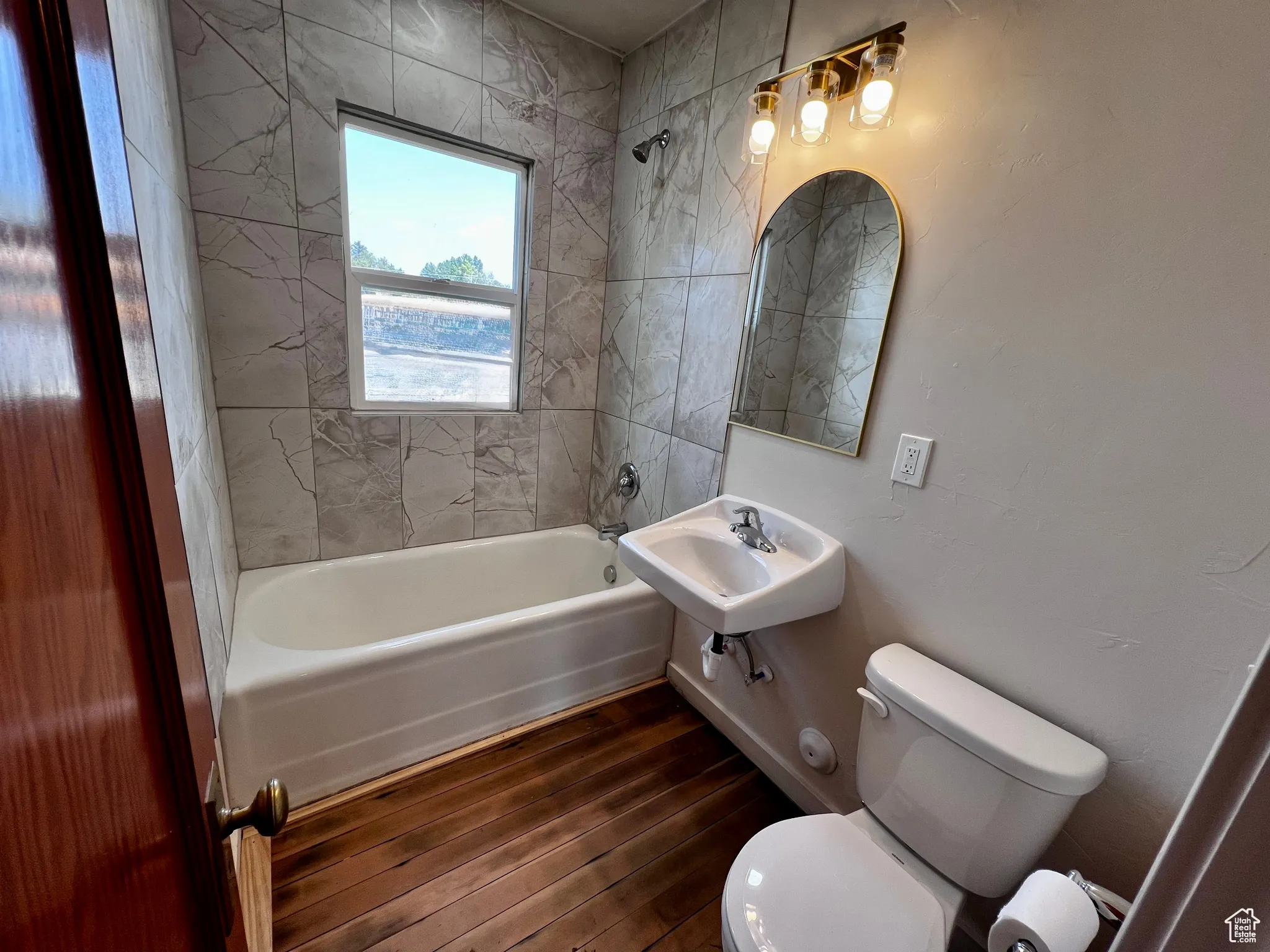 Bathroom featuring shower / tub combination and dark wood-style floors