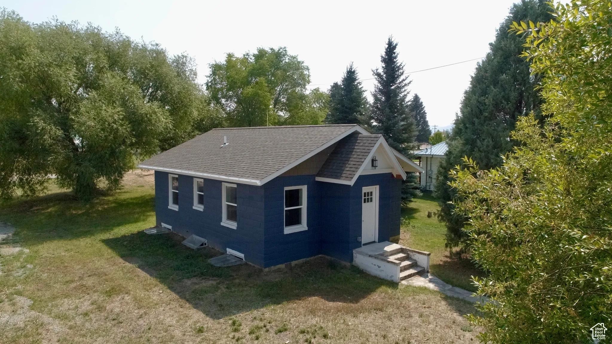 View of home's exterior with a lawn and roof with shingles