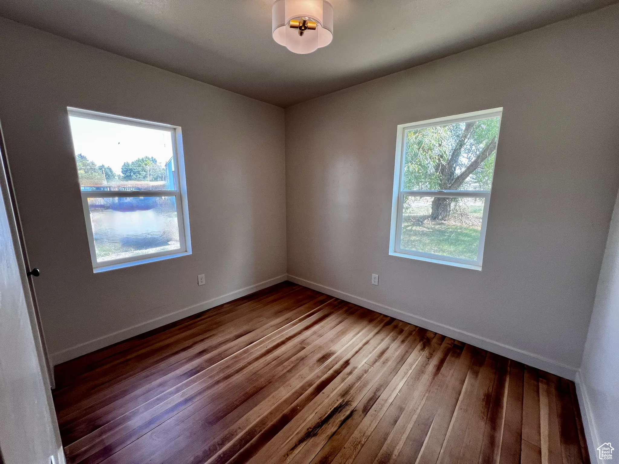 Unfurnished room with baseboards and wood-type flooring