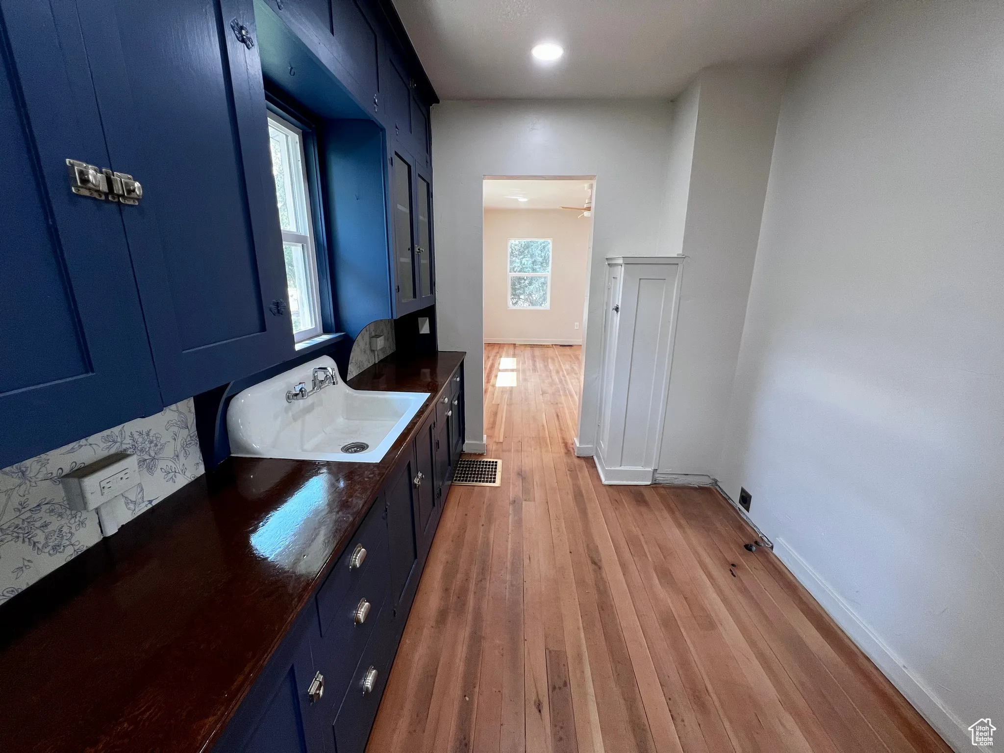 Interior space with blue cabinetry, light wood finished floors, dark stone counters, and recessed lighting
