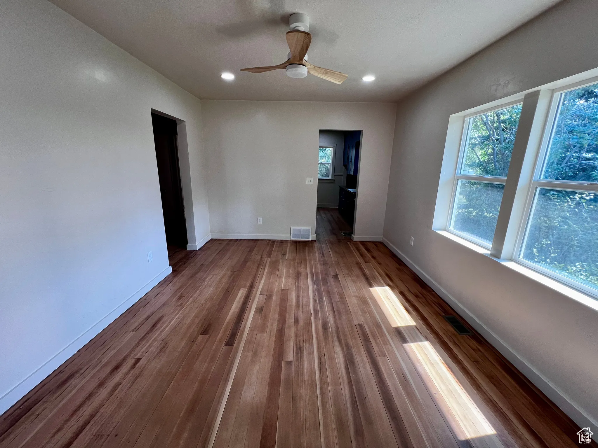 Unfurnished room with recessed lighting, plenty of natural light, dark wood-style floors, and ceiling fan