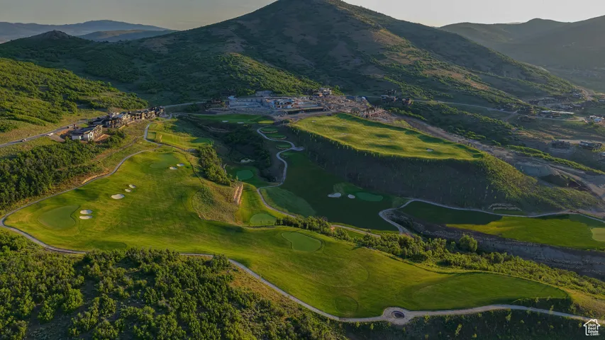 Aerial view of property's location featuring a golf course and a water and mountain view