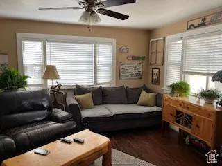 Living area featuring a ceiling fan and dark wood finished floors
