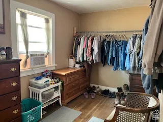 Walk in closet with light wood-style flooring and cooling unit
