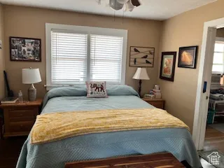 Bedroom with dark wood finished floors and a ceiling fan