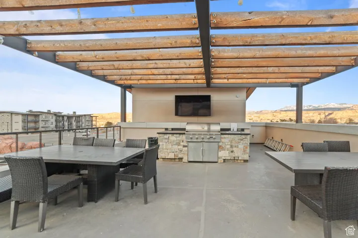 View of patio featuring outdoor dining area, an outdoor kitchen, and a mountain view