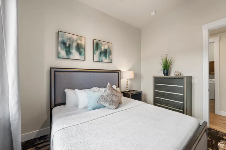Bedroom featuring wood finished floors, washer / clothes dryer, and wine cooler